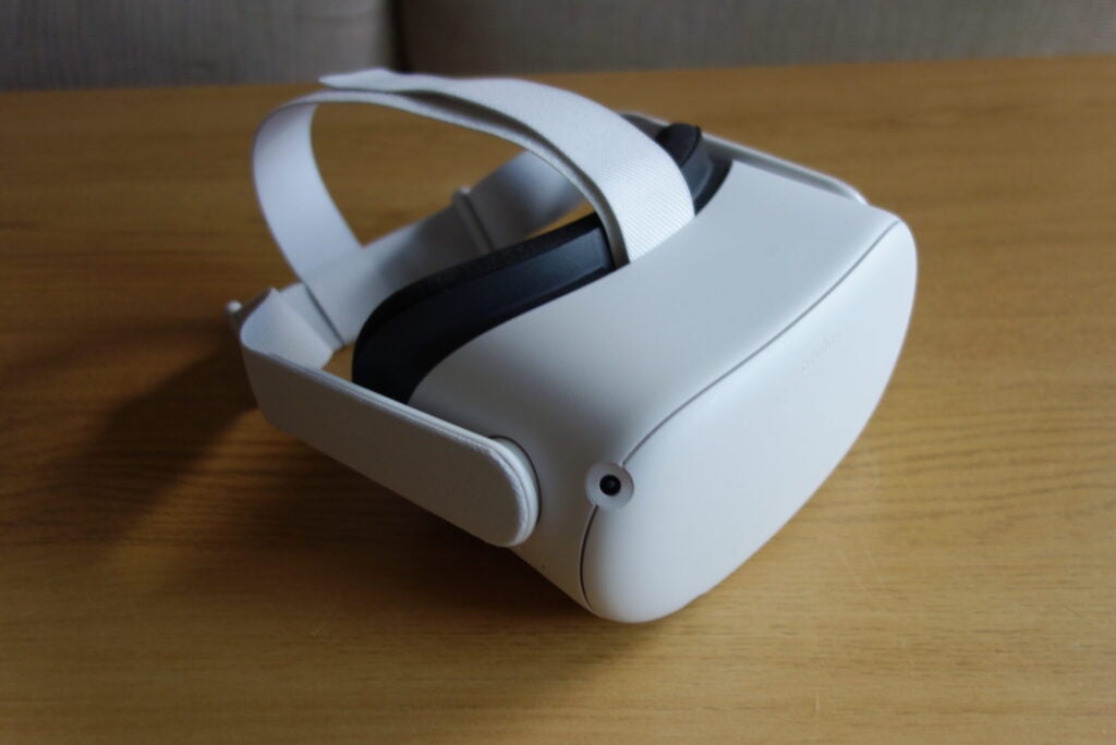 Eine wei&szlig;e Oculus Quest 2 auf einem Holztisch, Ansicht von hinten links
