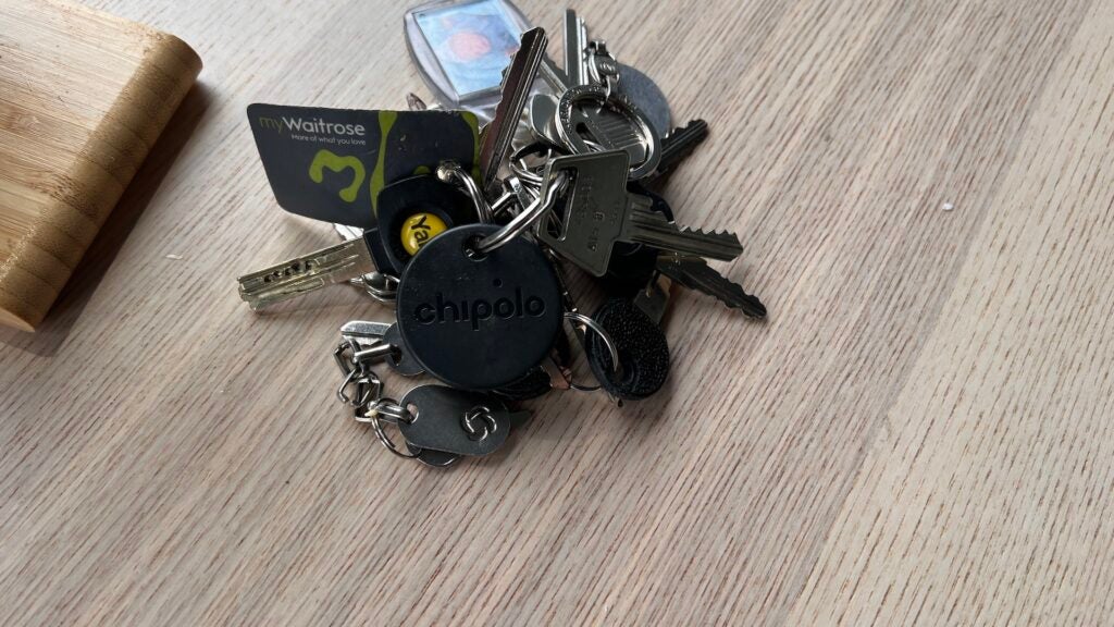Chipolo One Spot auf einem Tisch, befestigt an Schlüsseln