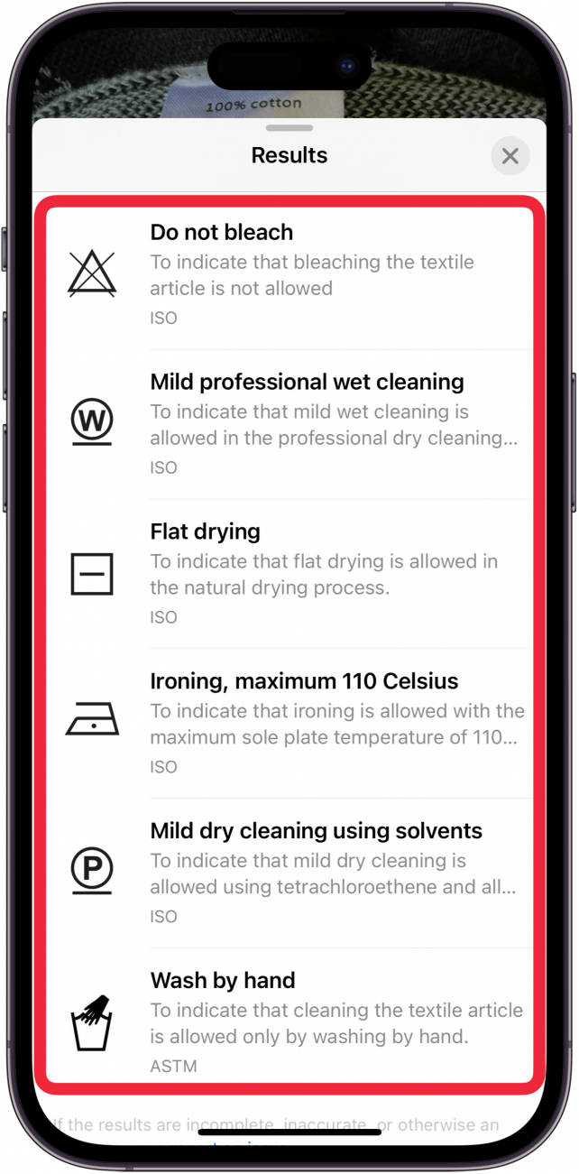 iPhone-Fotos-App mit geöffnetem erweiterten visuellen Nachschlagemenü, das verschiedene Wäschesymbole und ihre Bedeutung mit einem roten Kästchen umgibt