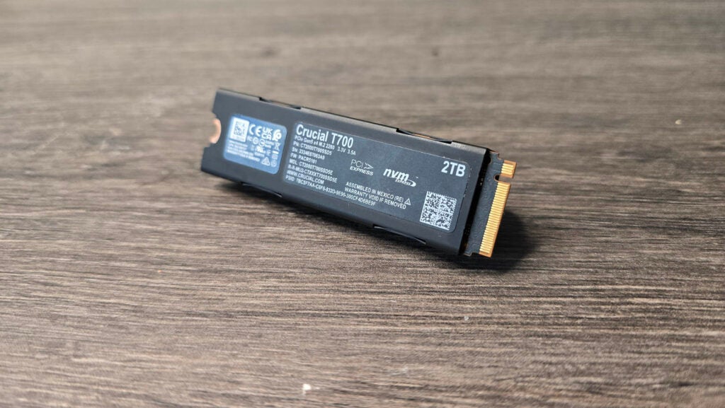Die T700 M.2 PCIe SSD von Crucial mit ihrer hinteren Rückplatte ist zu sehen. Crucial T700 2 TB M.2 SSD auf einer Holzoberfläche.