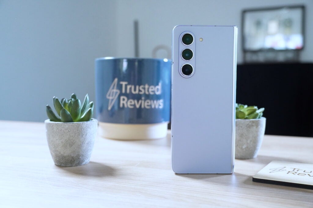 Samsung Galaxy Z Fold 5 auf dem Schreibtisch mit Pflanze und Testbecher.