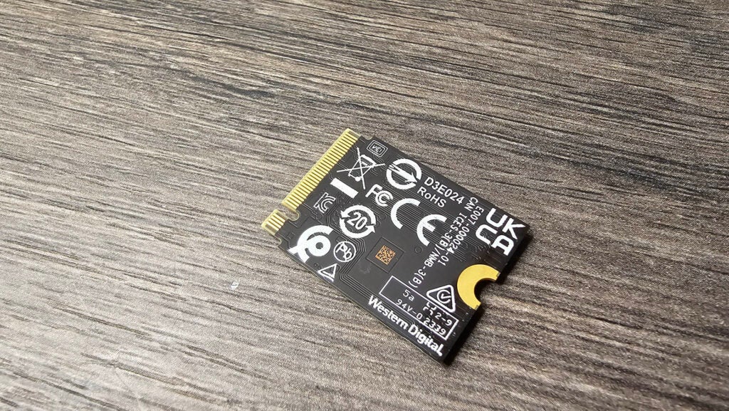 Die Rückseite einer WD_Black SN770M 1 TB M.2 PCIe 4.0 SSDWD_Black SN770 NVMe SSD auf einer Holzoberfläche.