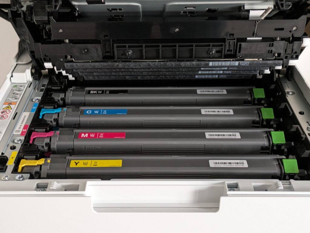 Der obere Teil des MFP ist geöffnet und zeigt die installierten Toner für Schwarz, Cyan, Magenta und Gelb