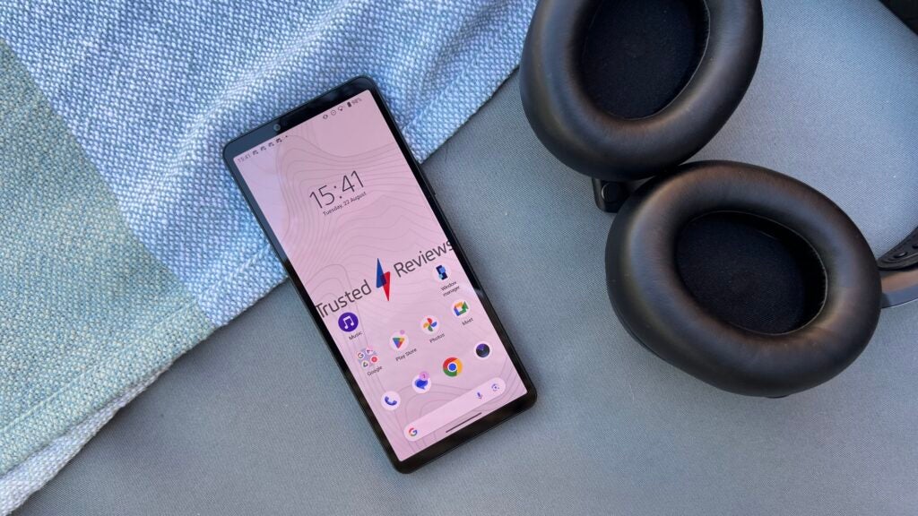 Sony Xperia 10 V Smartphone auf Tisch mit Kopfhörern.