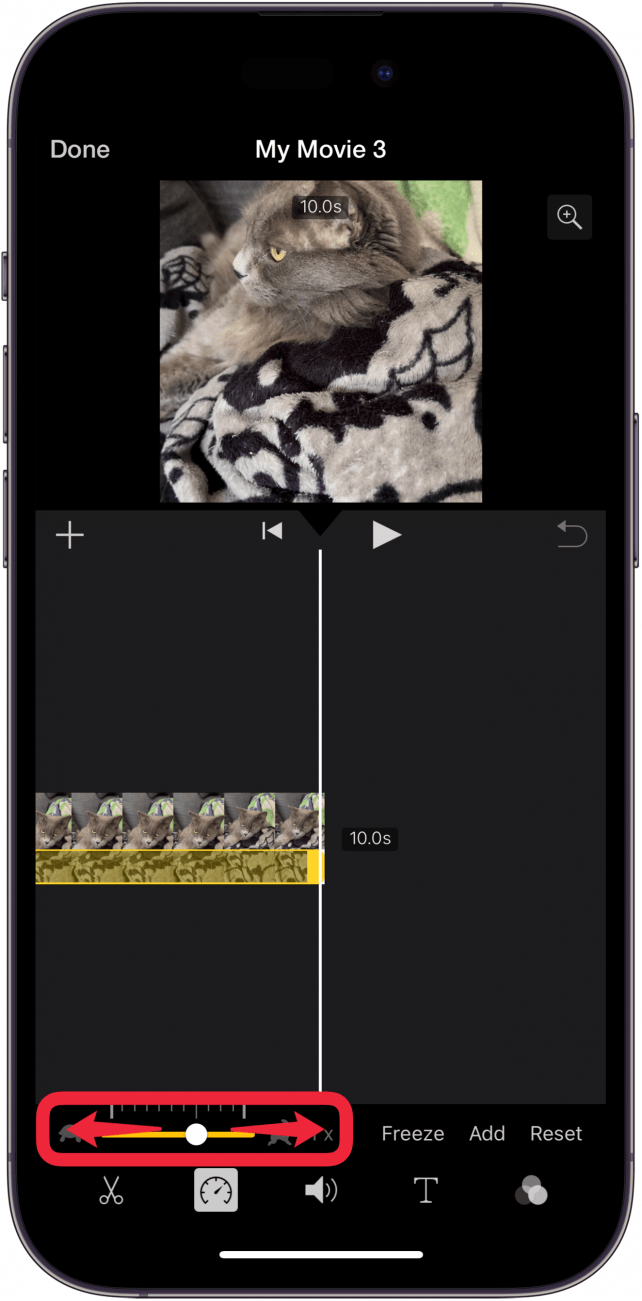 Bearbeitungsbildschirm der iPhone-iMovie-App mit einem roten Kästchen um den Geschwindigkeitsregler mit nach links und rechts zeigenden Pfeilen, die anzeigen, dass der Benutzer den Regler nach links oder rechts ziehen kann