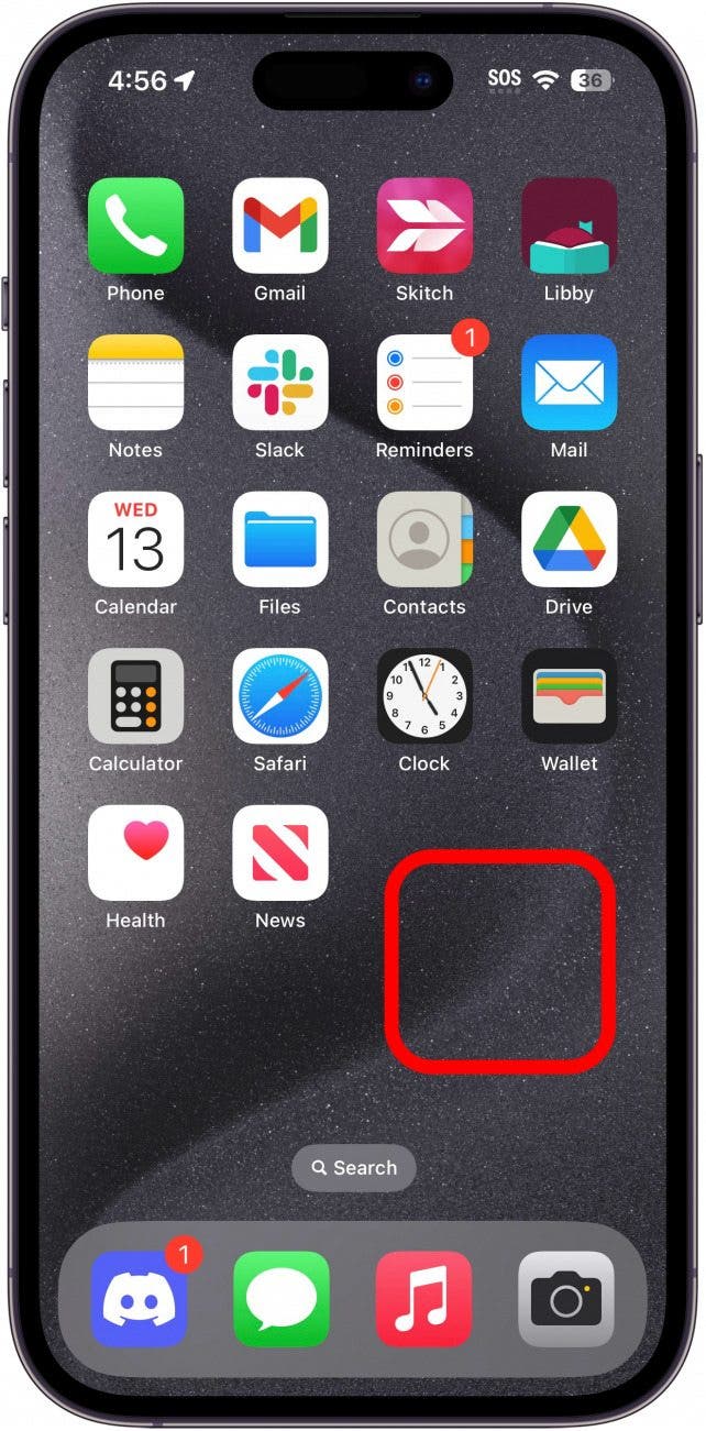 iPhone-Startbildschirm mit einem roten Kästchen um einen leeren Bereich, das anzeigt, dass dieser Bereich angetippt und gehalten werden soll