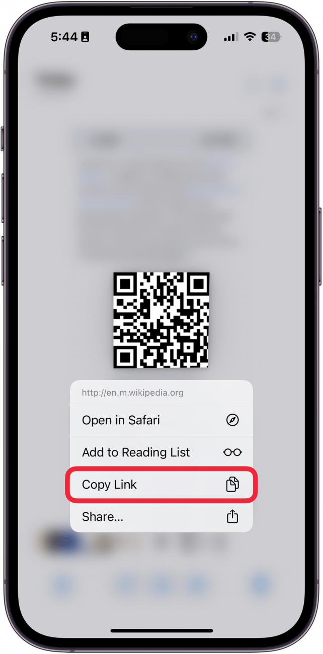 iPhone Photos App anzeigt einen Screenshot eines QR -Codes, in dem ein Kontextmenü nach dem Tippen auf den Code mit einem roten Kästchen rund um den Link zum Kopieren von Kopieren angezeigt wird