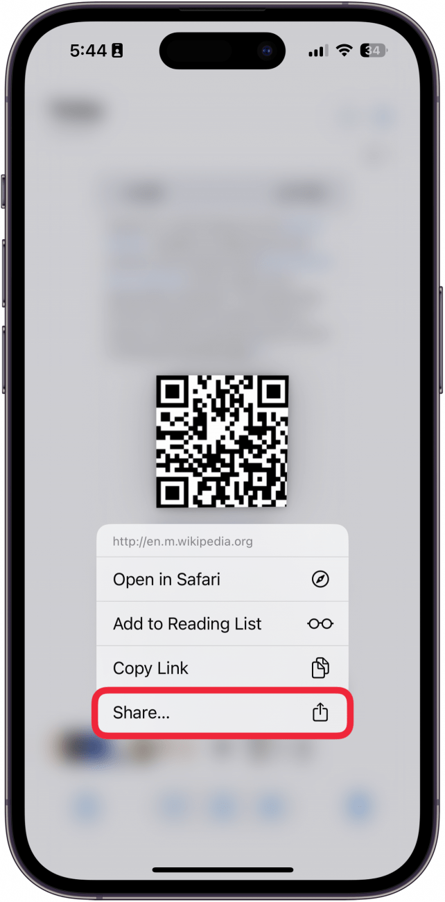 iPhone Photos App anzeigt einen Screenshot eines QR -Codes, in dem ein Kontextmenü nach dem Tippen auf den Code mit einem roten Box um Freigabeschaltfläche angezeigt wird