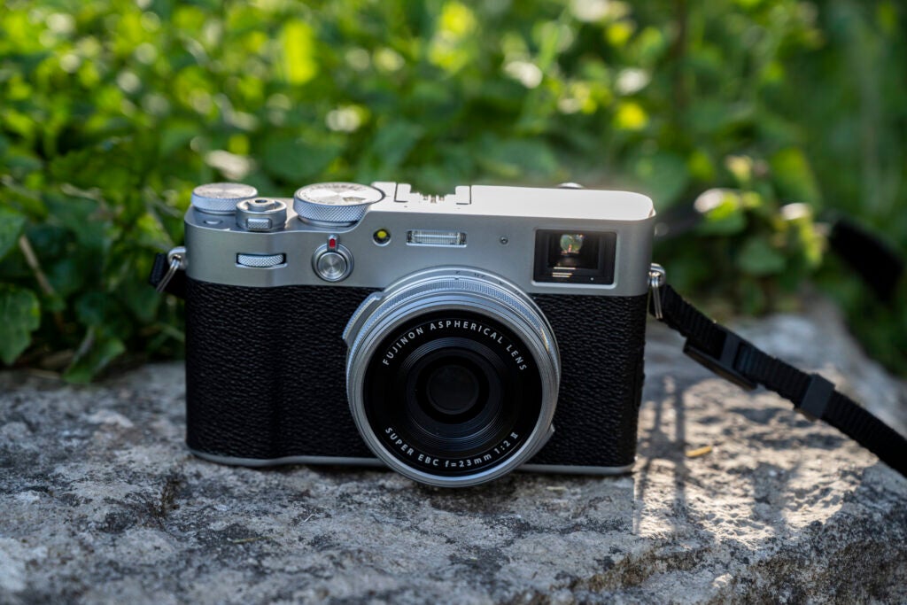 Vista frontal de una Fujifilm X100V negra sobre un bloque de hormigón