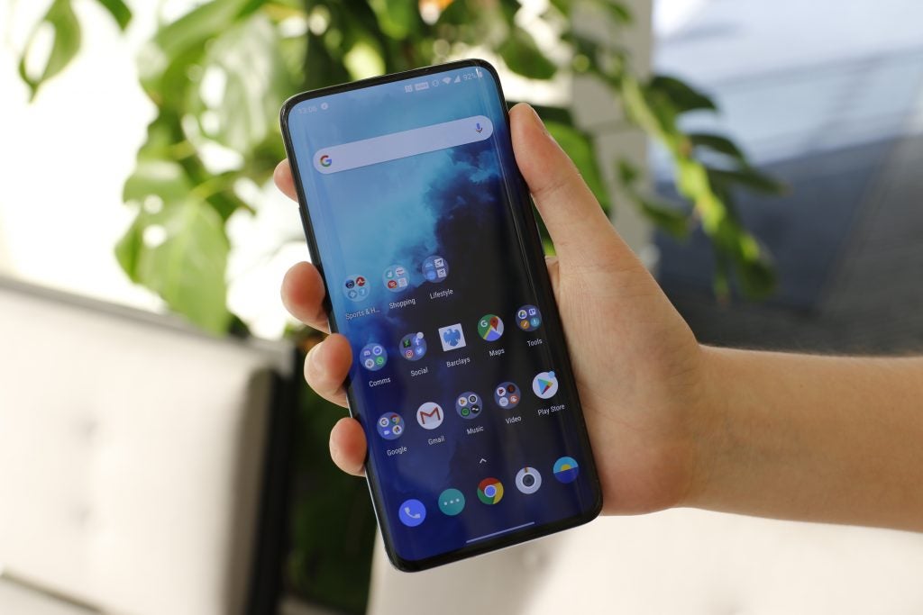 Un One Plus 7T Pro sostenido en la mano mostrando la pantalla de inicio