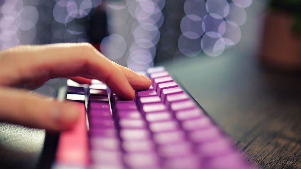 Primer plano de los dedos escribiendo en un teclado mecánico Ducky.