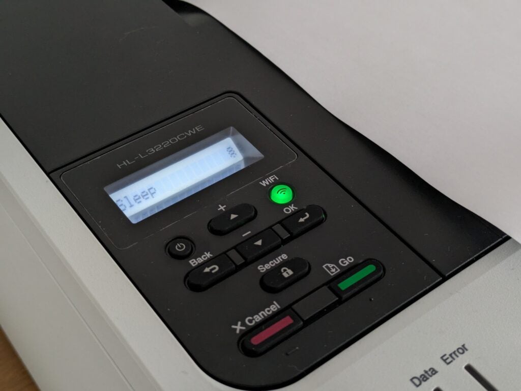 El panel de control de esta impresora.  La pantalla está iluminada y muestra 