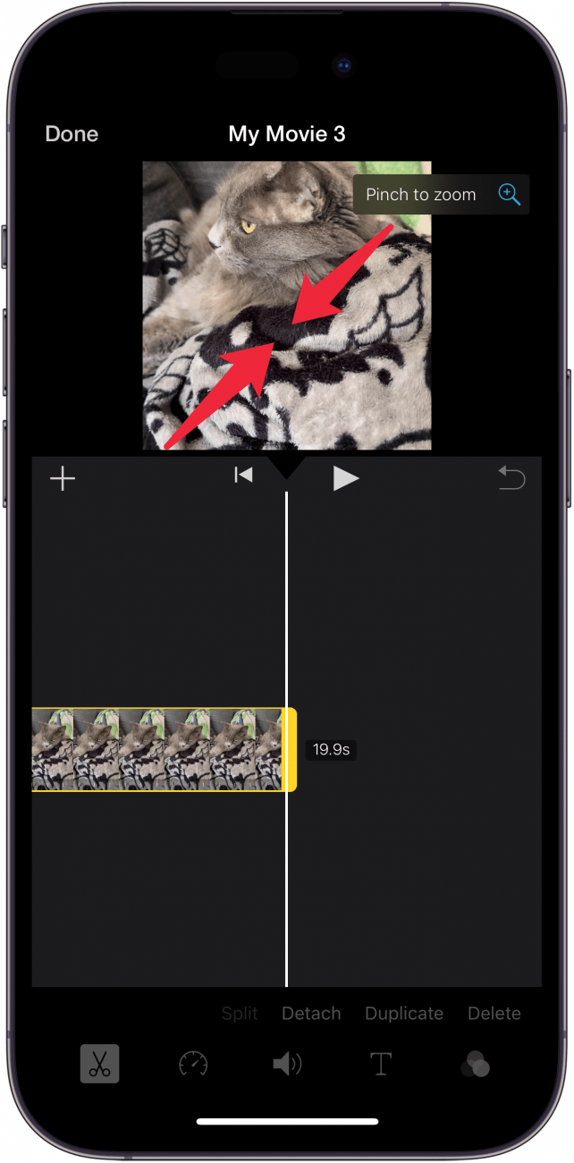 Pantalla de edición de la aplicación iPhone Imovie con flechas rojas apuntando hacia adentro en el video, lo que indica que el usuario debe pellizcar para alejar el video.