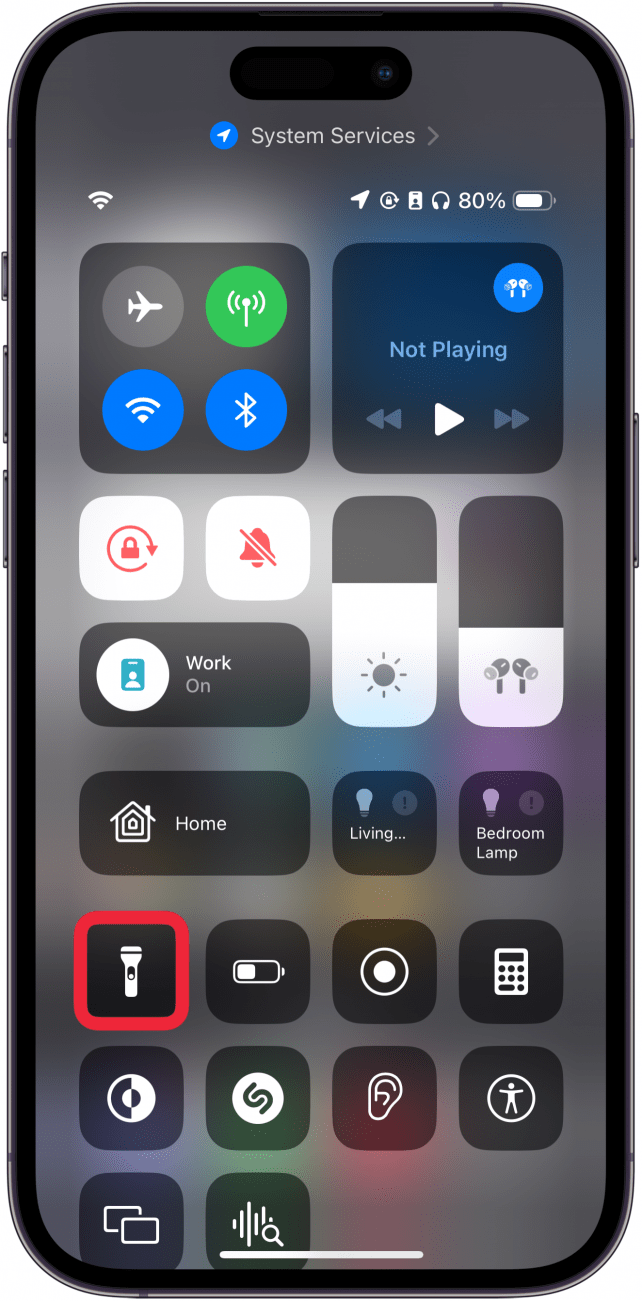 Centro de control del iPhone con un cuadro rojo alrededor del icono de la linterna.