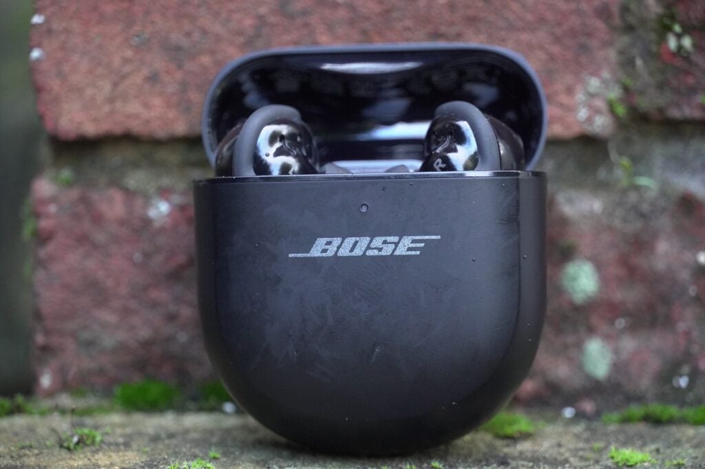 Auriculares Bose QuietComfort Ultra contra una pared