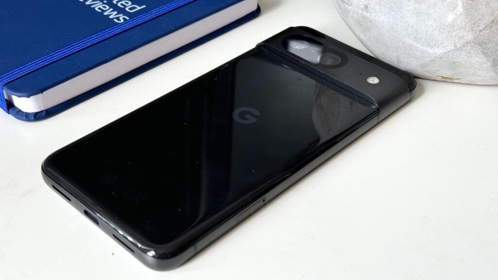 Teléfono inteligente Google Pixel 8 sobre un escritorio blanco con computadora portátil.