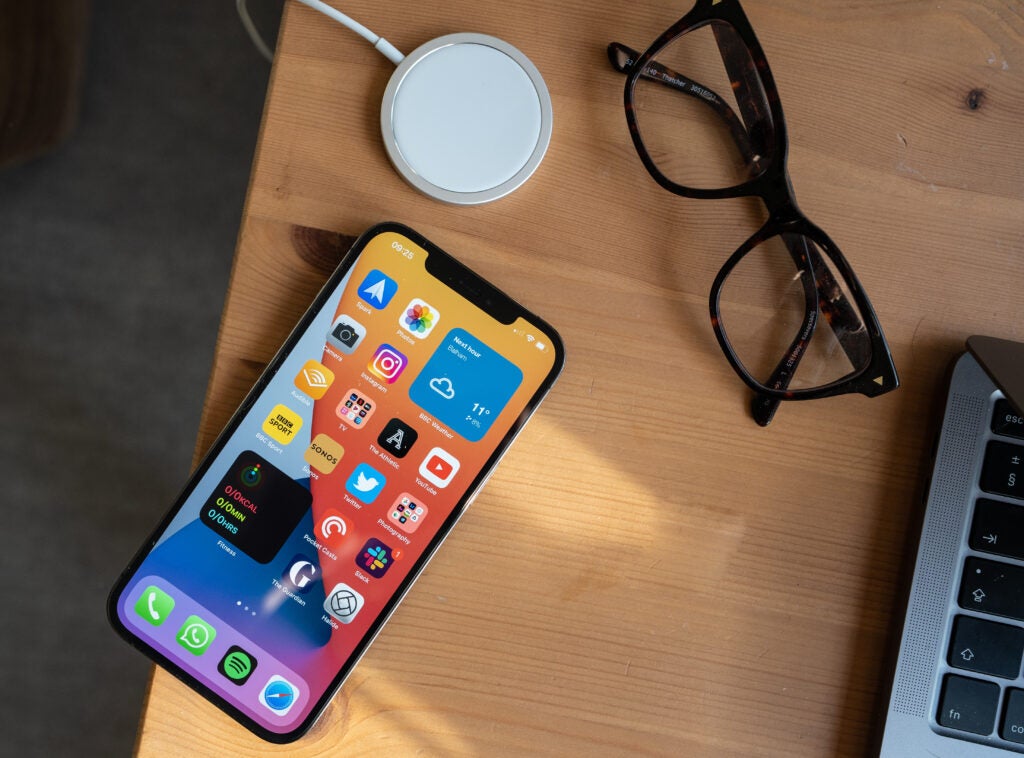 Un iPhone 12 Pro Max apoyado sobre una mesa de madera