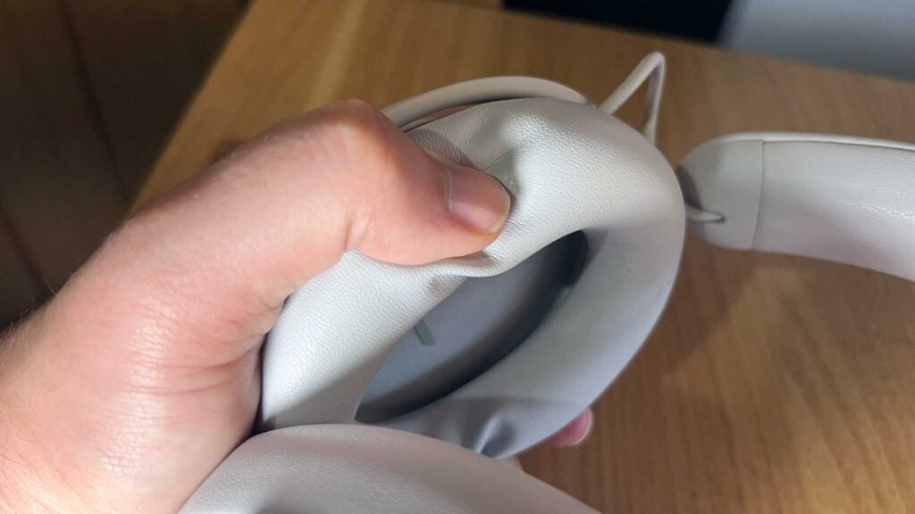 Presionando las copas de los auriculares Alienware Pro.