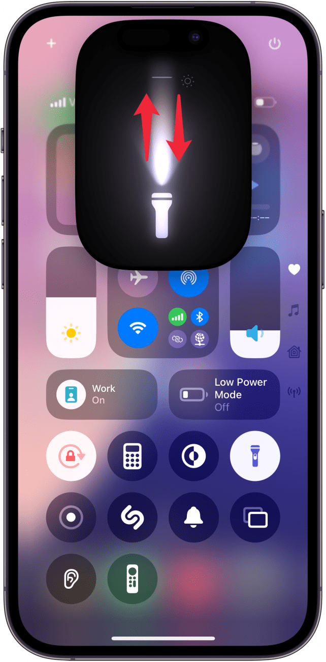 Centro de control de iPhone con UI de linterna y flechas rojas apuntando hacia arriba y hacia abajo
