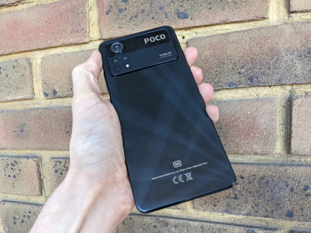 Panneau arrière du Poco X4 Pro, contre un mur