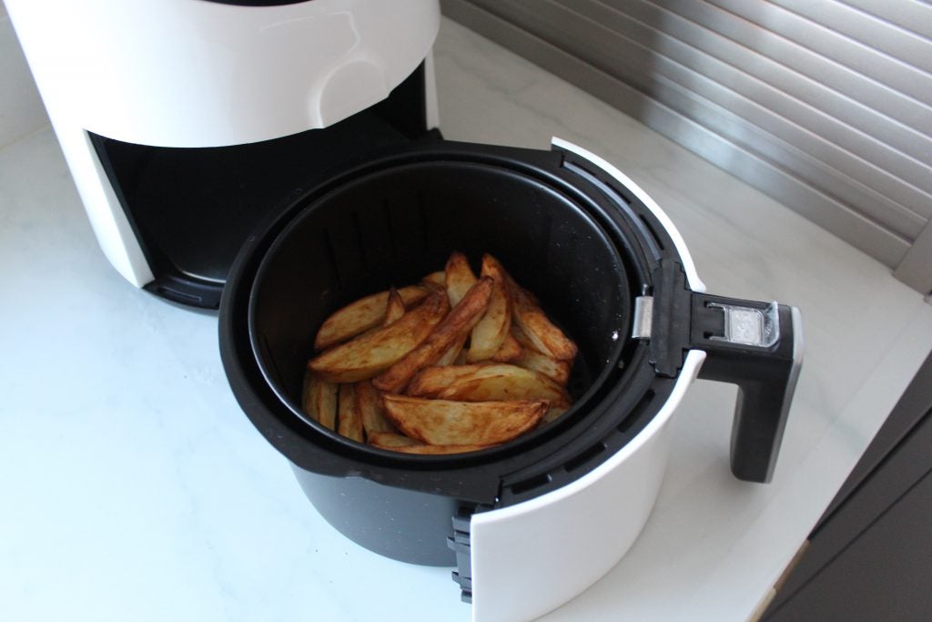 Vue rapprochée d'un conteneur Quest Digital LCD Air Fryer avec des frites frites conservées à l'intérieur
