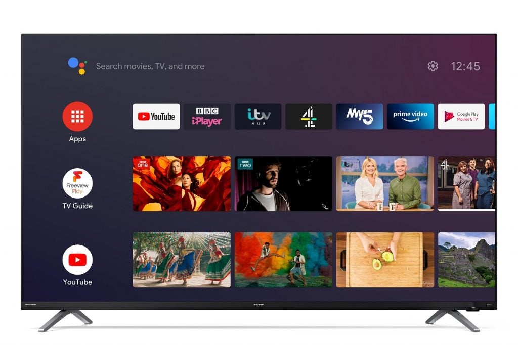 Téléviseur Sharp 50KU 4FE C1 avec support affichant les applications, le guide TV et la section youtube avec un bouton de réglage en haut à gauche et la barre de recherche de l'assistant Google en haut à droite