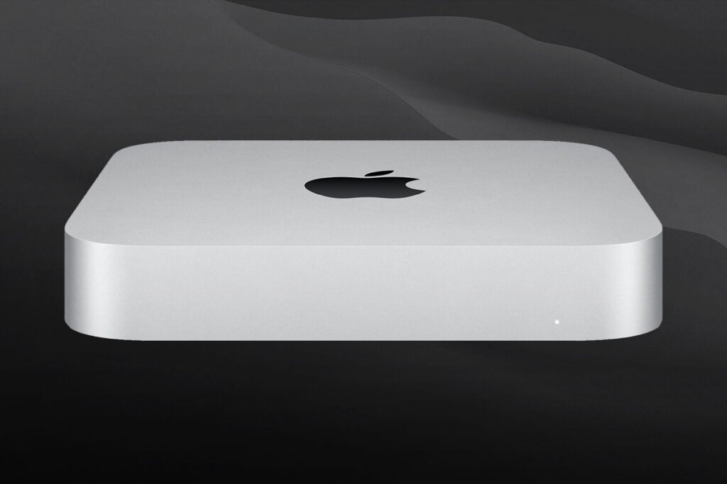 Vue latérale inférieure avant d'un Mac mini blanc reposant sur un fond noir