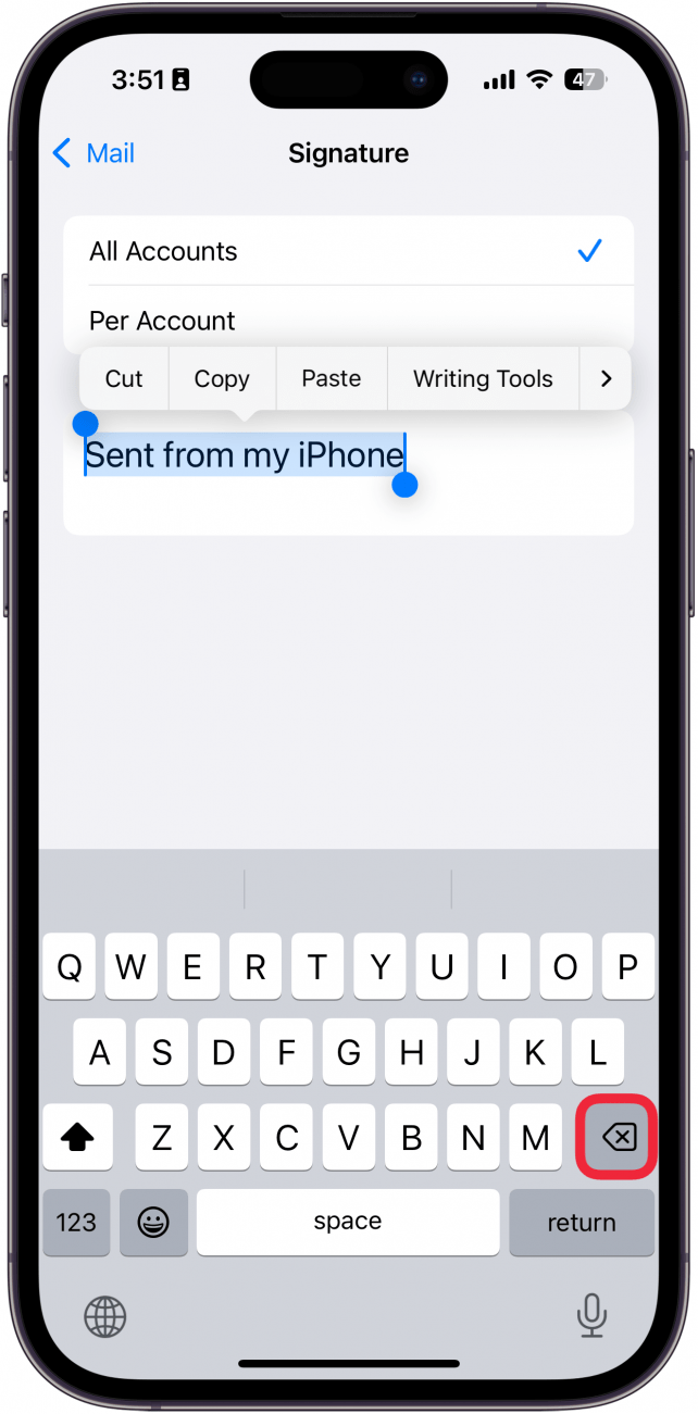 Une capture d'écran des paramètres de signature d'e-mail iPhone affichant le clavier avec une boîte rouge autour de la touche arrière